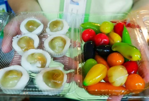 Visitor enjoying pad thai while exploring Wat Yai Chai Mongkhon and chatting with local vendors