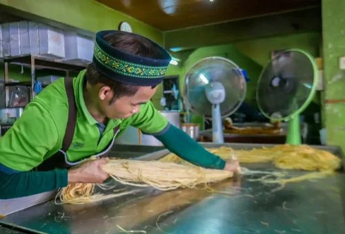 Visitor enjoying kanom jeen while exploring Wat Phra Ram and exploring UNESCO World Heritage ruins