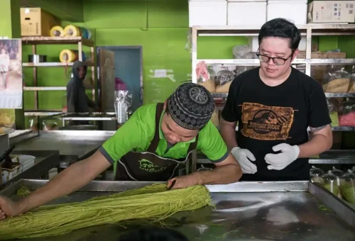 Visitor enjoying fried bananas while exploring Wat Phu Khao Thong and trying Thai desserts