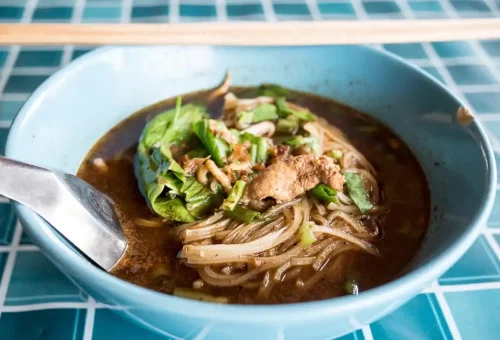 Visitor enjoying local market sweets while exploring Wat Thammikarat and enjoying sunset at ancient temples