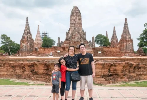 Visitor enjoying roti sai mai while exploring Wat Chaiwatthanaram and chatting with local vendors