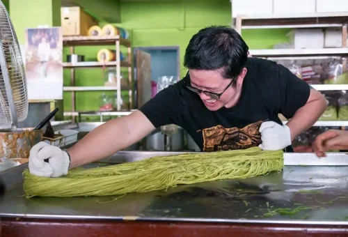Visitor enjoying mango sticky rice while exploring Wat Ratchaburana and learning about Siamese history