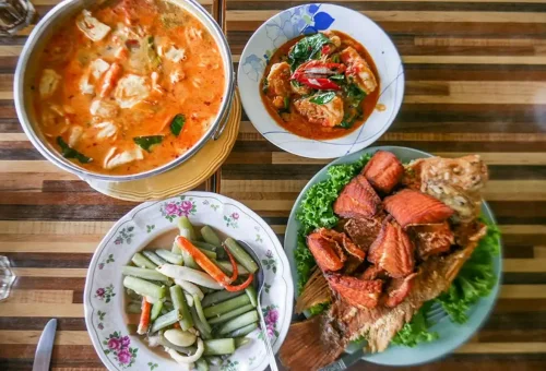 Visitor enjoying mango sticky rice while exploring Wat Ratchaburana and cruising along the Chao Phraya