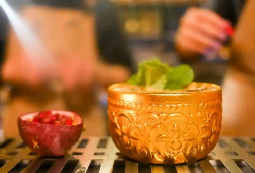 Group laughing and enjoying Thai tapas with drinks during the bar crawl