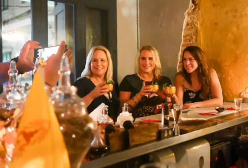 Bangkok night street scene with tuk tuk zooming past lively bars and night markets