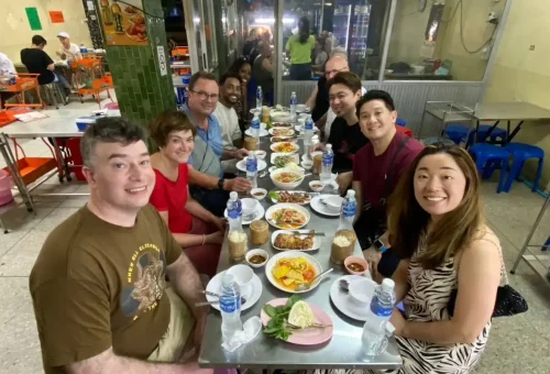 Guest enjoying grilled river prawns at Ratchawat Market during Bangkok Midnight Food Tour by Tuk Tuk with Phuket Travel Store