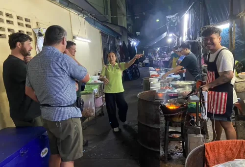 Guest enjoying tom yum soup at Soi Suan Plu during Bangkok Midnight Food Tour by Tuk Tuk with Phuket Travel Store