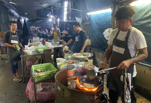 Guest enjoying Thai oyster omelette at Victory Monument during Bangkok Midnight Food Tour by Tuk Tuk with Phuket Travel Store
