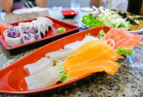 Vegan sashimi and fresh vegetable rolls served on red sushi tray