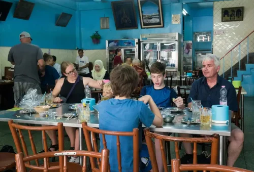 Tourists dining in a local Thai restaurant with traditional interior