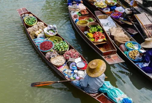 Floating boats loaded with Thai vegetables, herbs, and spices