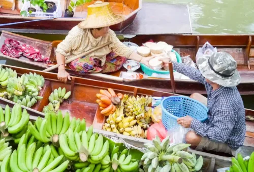Thai vendor selling bananas and coconut treats from a canal boat