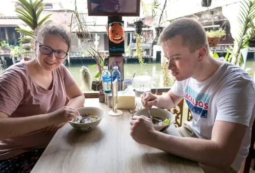 Travelers enjoying noodle soup at a waterside restaurant along Bangkok’s historic canals