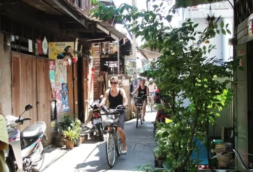 Tourists cycling through narrow Bangkok alleyways