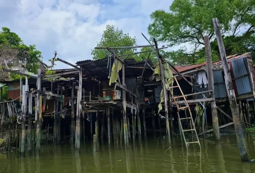 Rustic wooden stilt house over Bangkok canal