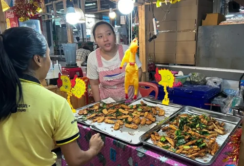 Local vendor selling Thai fried snacks at market stall