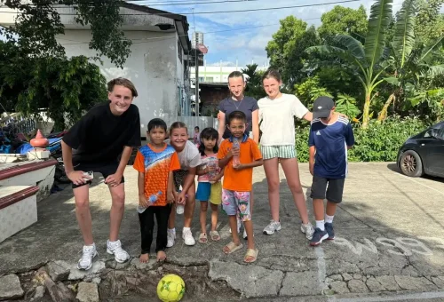 Visitors playing with local kids during bike stop in Bangkok