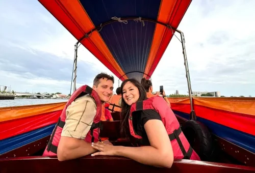 Group of travelers gathering under colorful umbrellas beside parked bicycles.