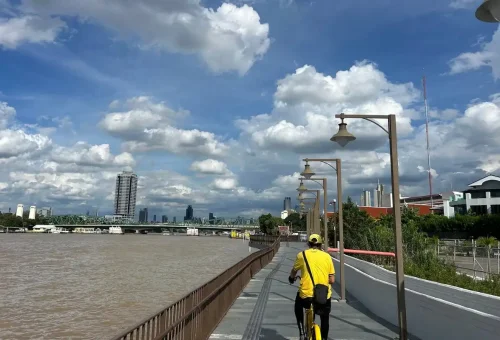 Two smiling female tour guides flashing peace signs on a longtail boat.
