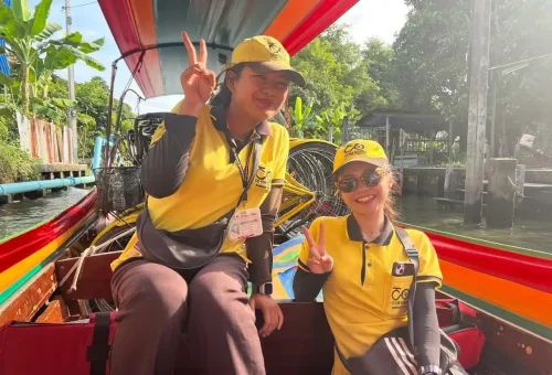 Tourists enjoy a scenic Bangkok canal ride on a colorful longtail boat.