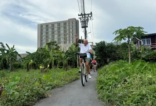 Longtail boat passes through a watergate on a Bangkok canal with passengers on board.