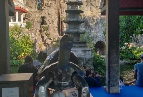 Pagoda-style turtle shrine beside peaceful pond