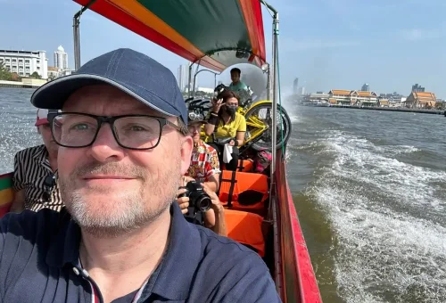 Tourists smiling on longtail boat during canal cruise