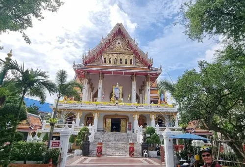 Ornate Thai temple with colorful roof and tourists