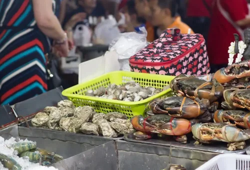 Live seafood and shellfish on ice at a Chinatown night market stall