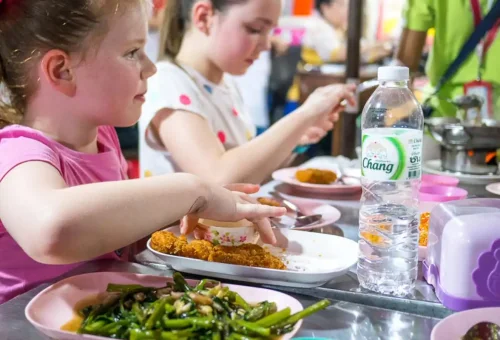Children enjoying Thai dishes like fried vegetables and chicken on tour