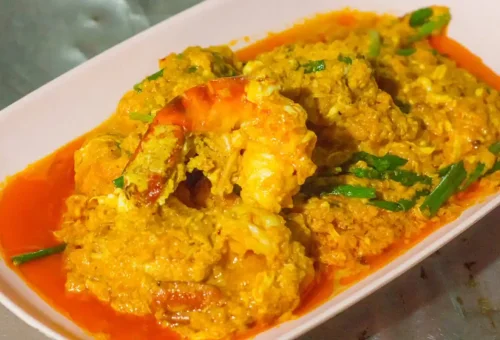 Thai-style curry prawns in yellow curry sauce on a white plate