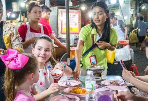 Family with kids dining at Chinatown street food tour, guided by local expert