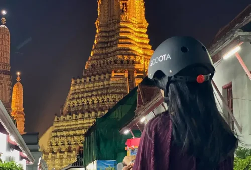 A rider gazes at the illuminated Wat Arun — one of the most iconic stops on the night tour.