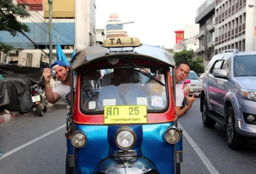 Travelers enjoying a tuk tuk ride through Bangkok streets