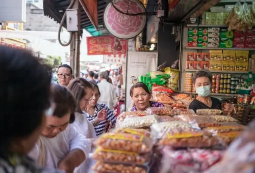Tourists buying snacks at a local shop in Bangkok Chinatown