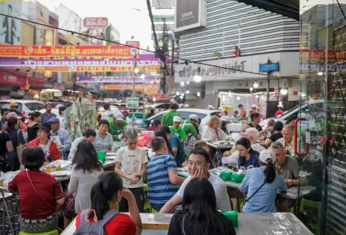 Locals and tourists dining at busy Bangkok street food stalls