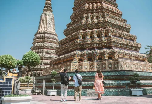 Tourists admiring the intricate chedis at Wat Pho, Bangkok