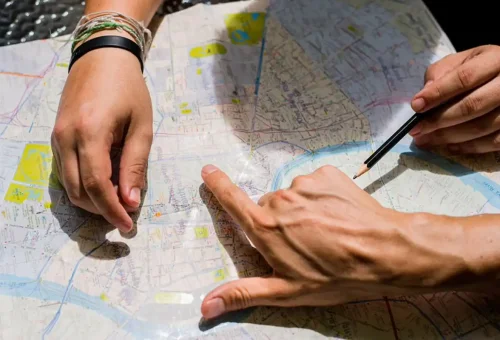 Travelers planning a route using a detailed map of Bangkok