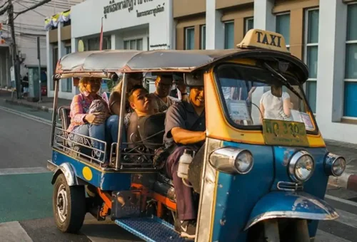 Tourists laughing together during a tuk tuk ride in Bangkok