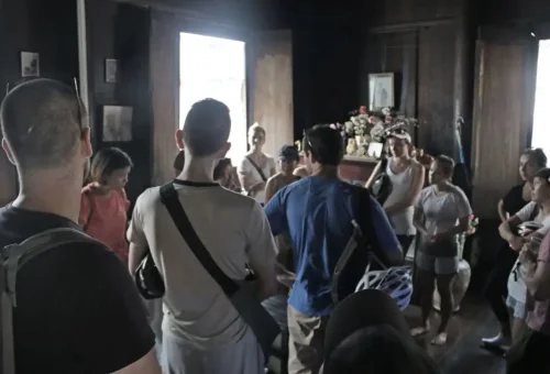 Tour group standing inside a traditional wooden house