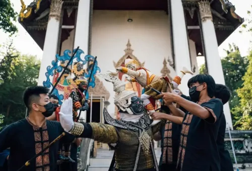 Traditional Thai puppet performance in front of a temple