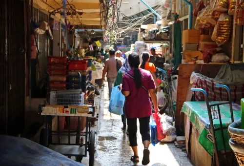 Narrow local market alley with people and fresh produce