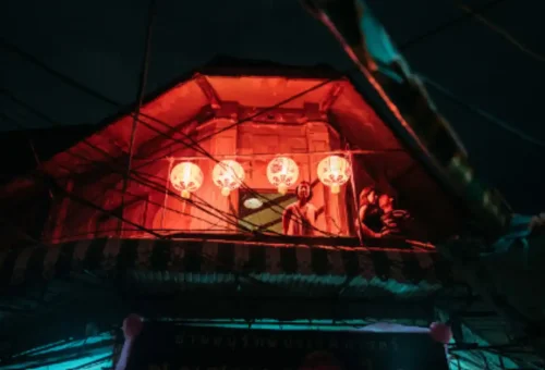 Chinese lantern-lit upper floor with people observing below
