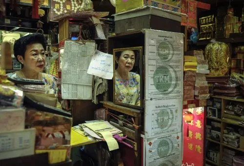 Local woman behind counter in an old Chinatown store