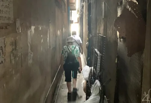 Visitors walking through an ultra-narrow hidden alley in Bangkok Chinatown