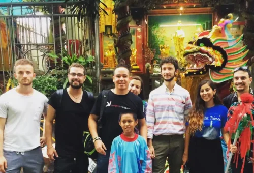 Tour group in Bangkok Chinatown standing in front of dragon sculpture