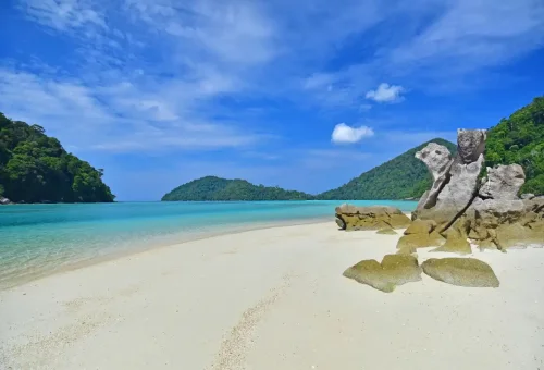 Scenic beach on Surin Islands with unique rock formations and tropical hills