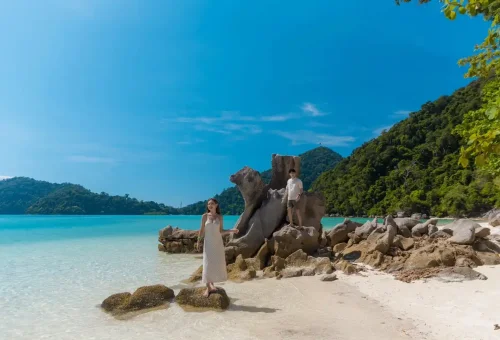 Couple posing by iconic rock formations on a Surin Islands beach