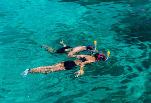 Two people snorkeling in the clear blue waters of Surin Islands