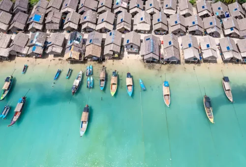Woman relaxing on a large driftwood tree by the beach on Surin Islands